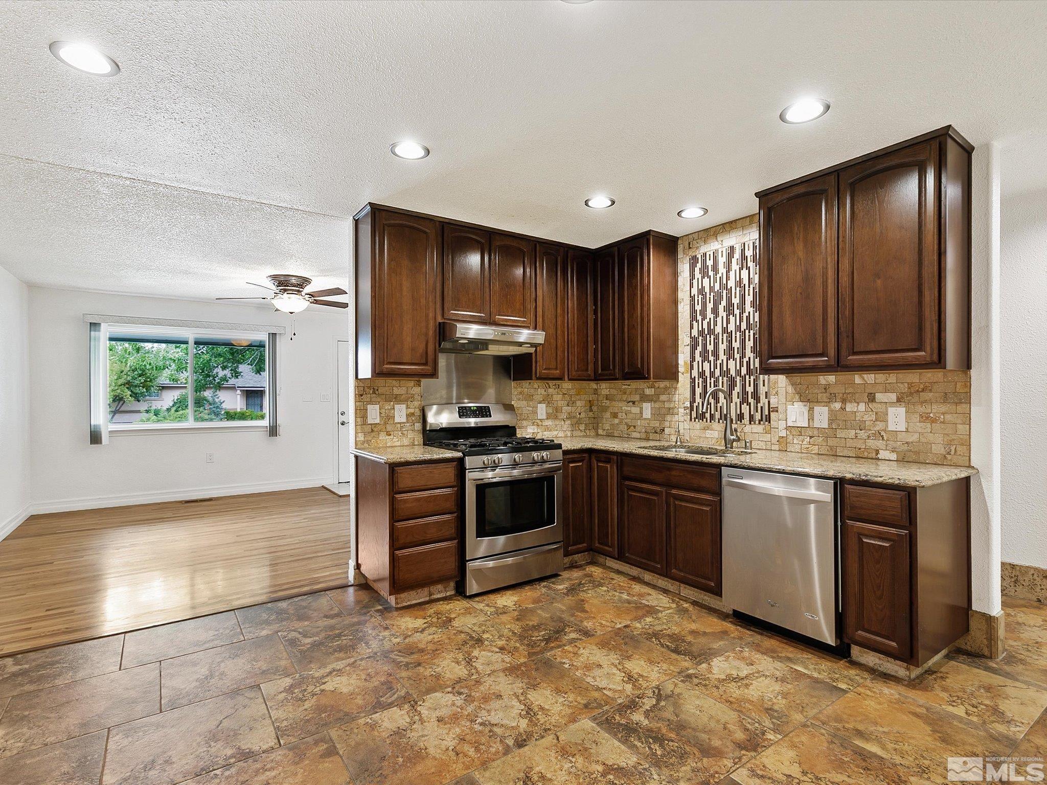 a kitchen with stainless steel appliances granite countertop a stove sink and cabinets