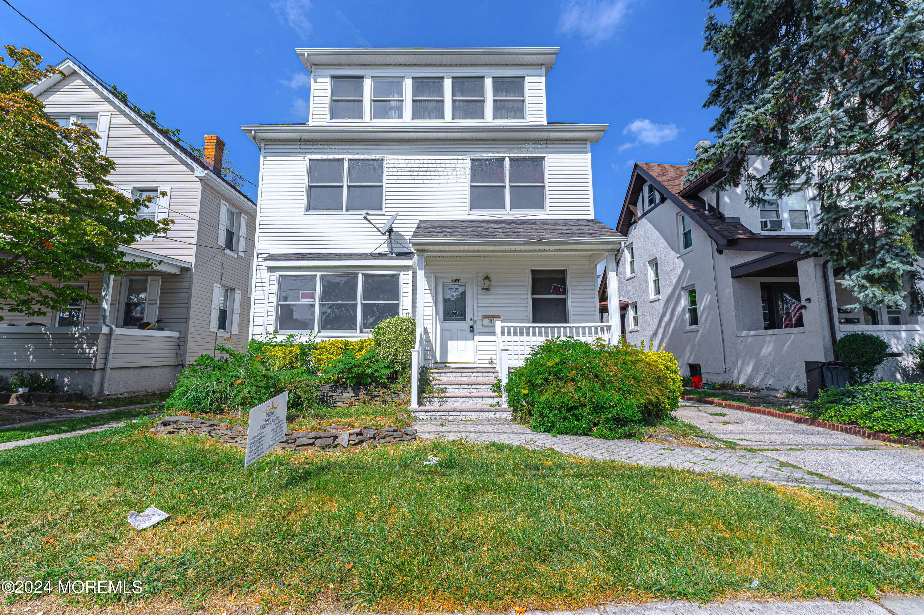 a front view of a house with a yard and green space