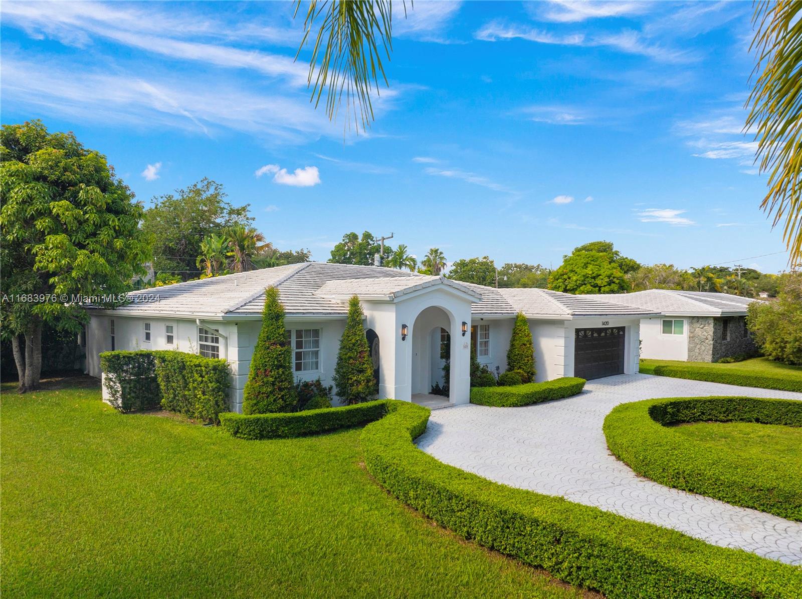 a front view of a house with a garden