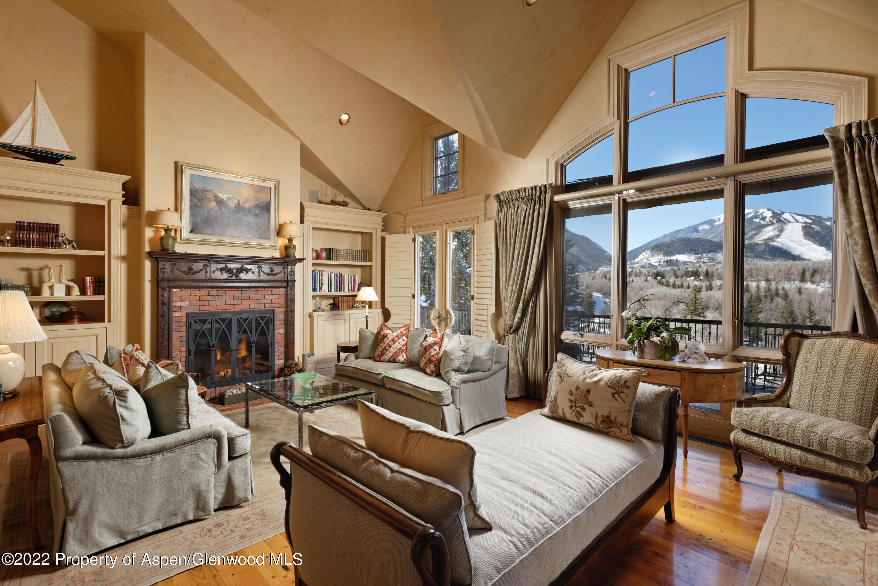 a living room with furniture fireplace and a large window