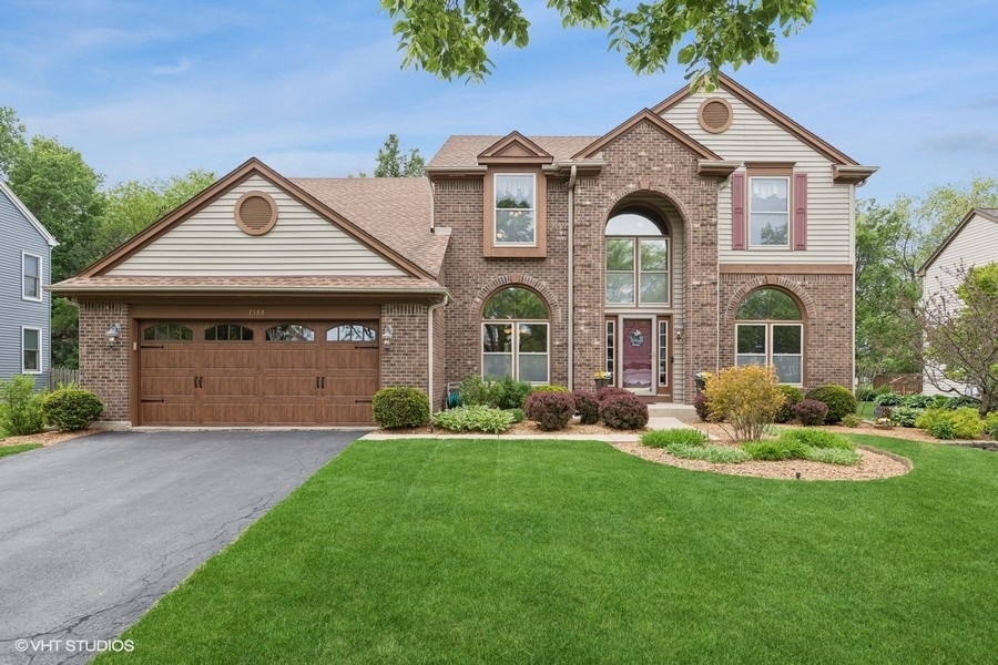 a front view of a house with a yard and garage