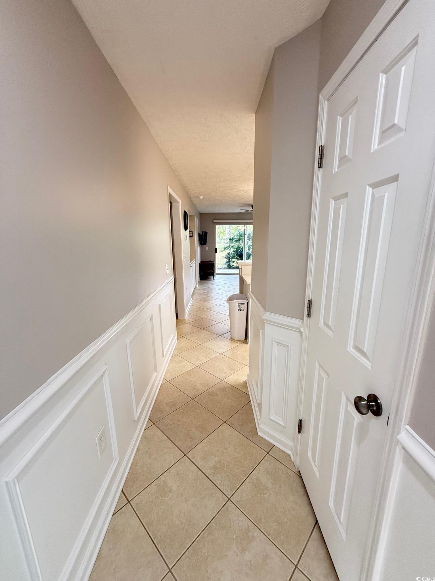 Corridor featuring a textured ceiling and light ti