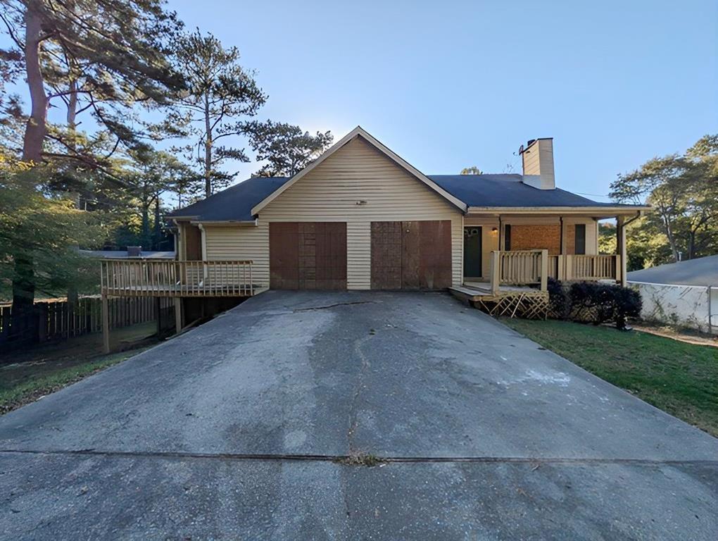 a view of a house with a yard and large trees