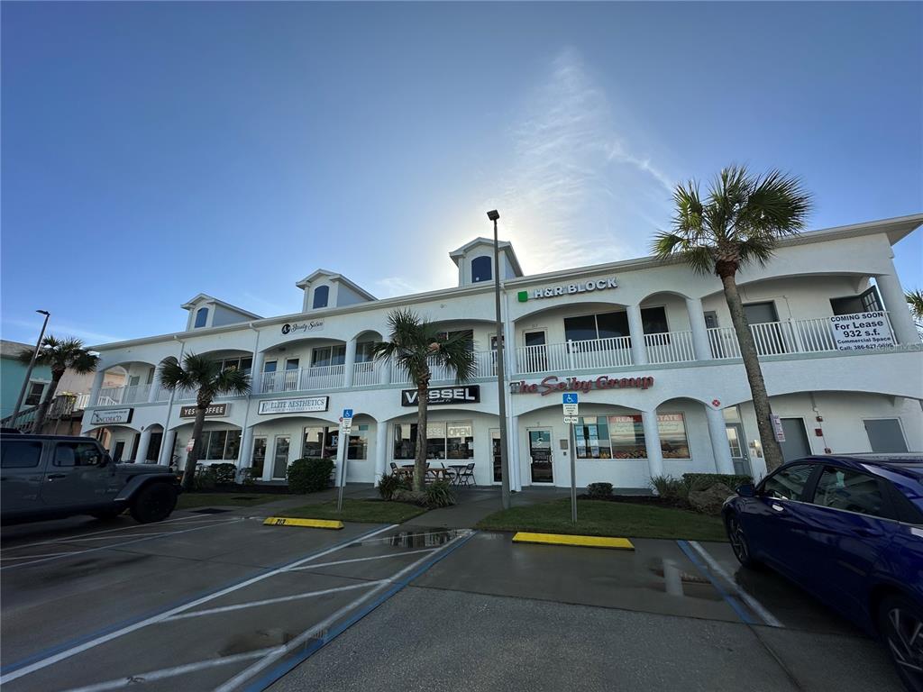 a front view of a building with lots of cars parked