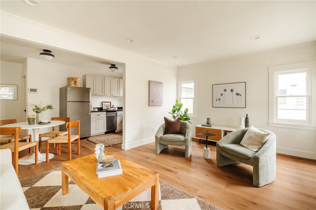 a living room with furniture wooden floor and a large window