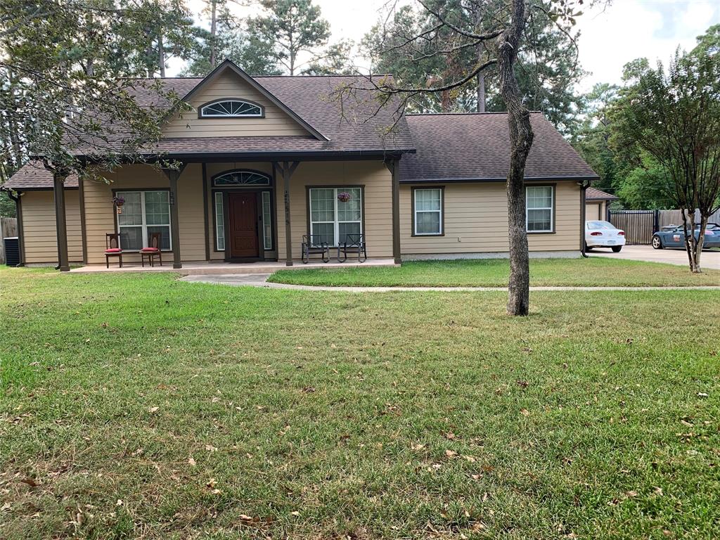 a view of a brick house with a big yard and large trees