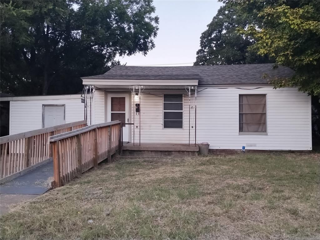 a view of a house with a small yard and wooden fence