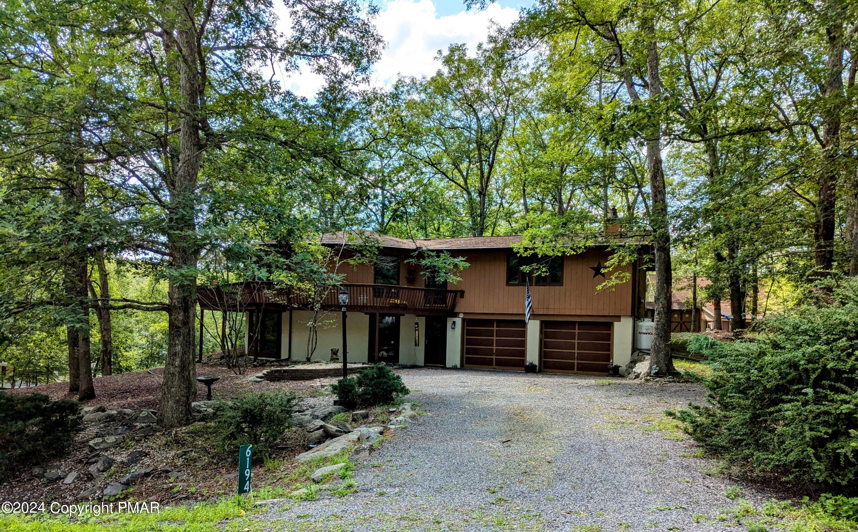 a view of a house with a yard and large tree