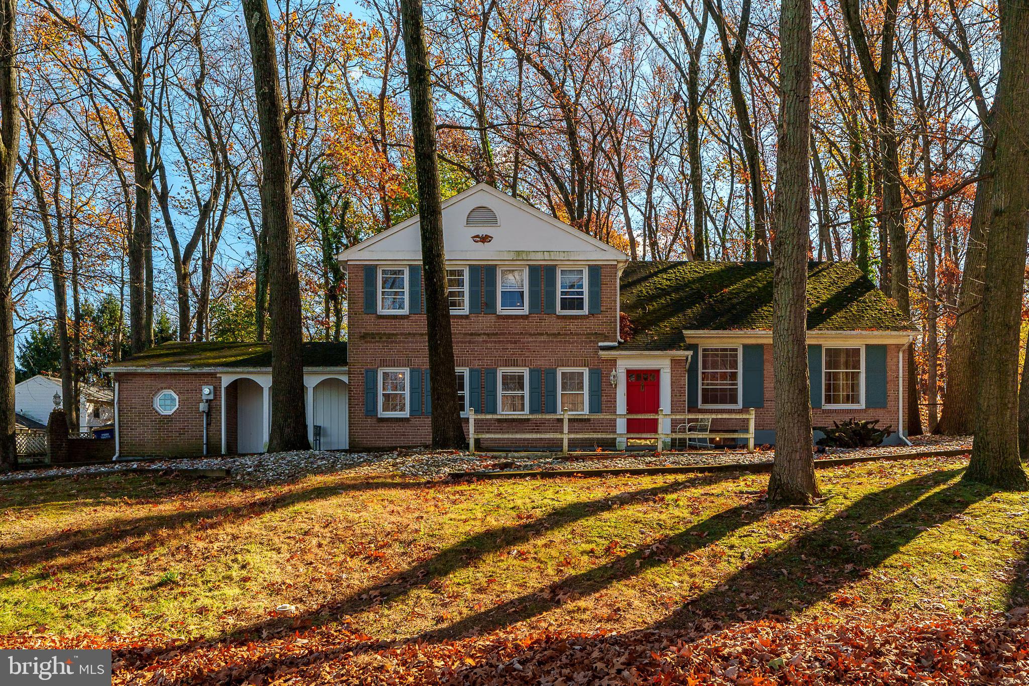 a front view of a house with large trees