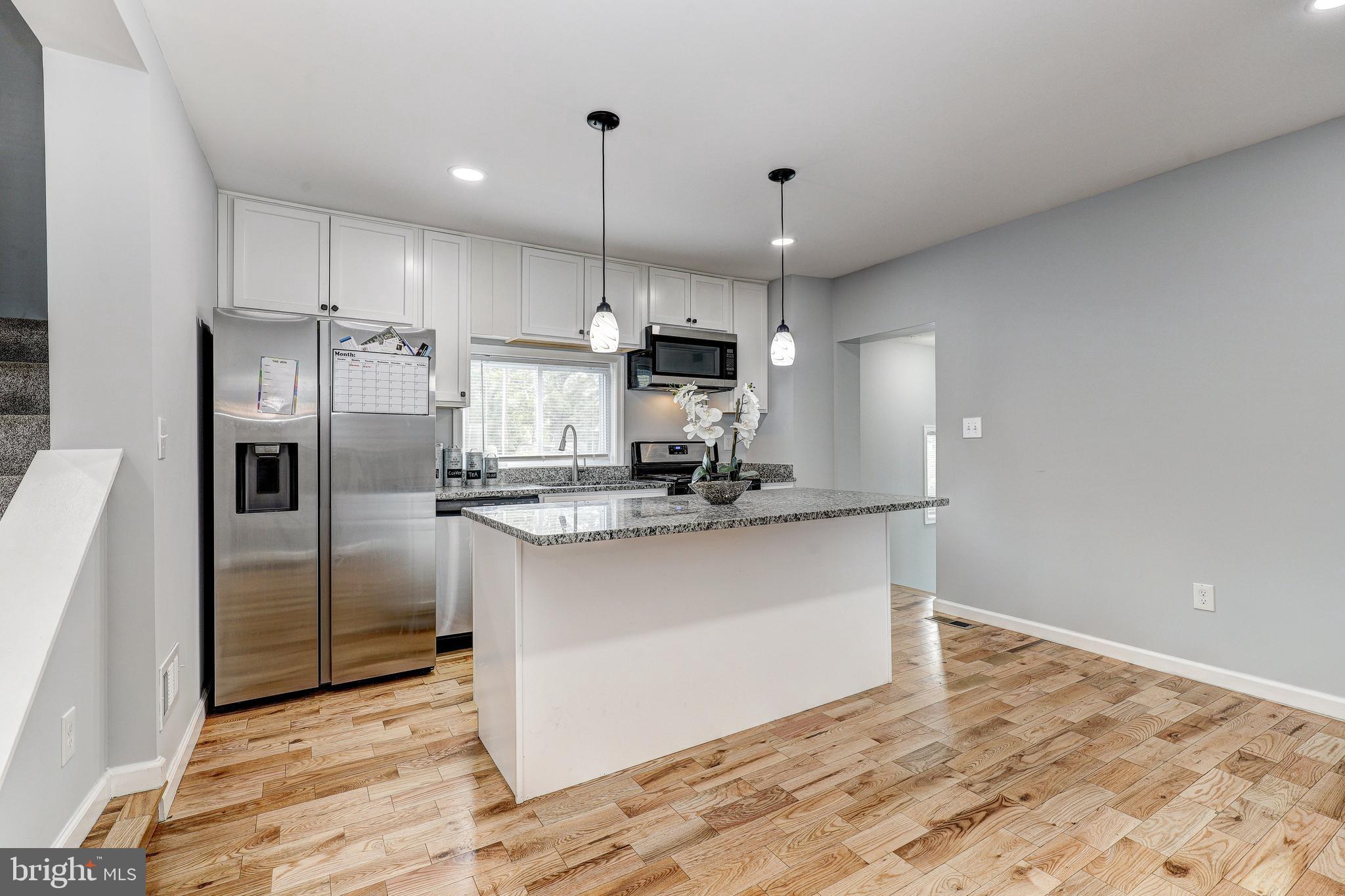 a kitchen with kitchen island a counter top space stainless steel appliances and cabinets