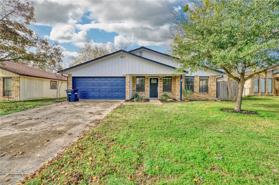 Ranch-style house with a garage and a front lawn