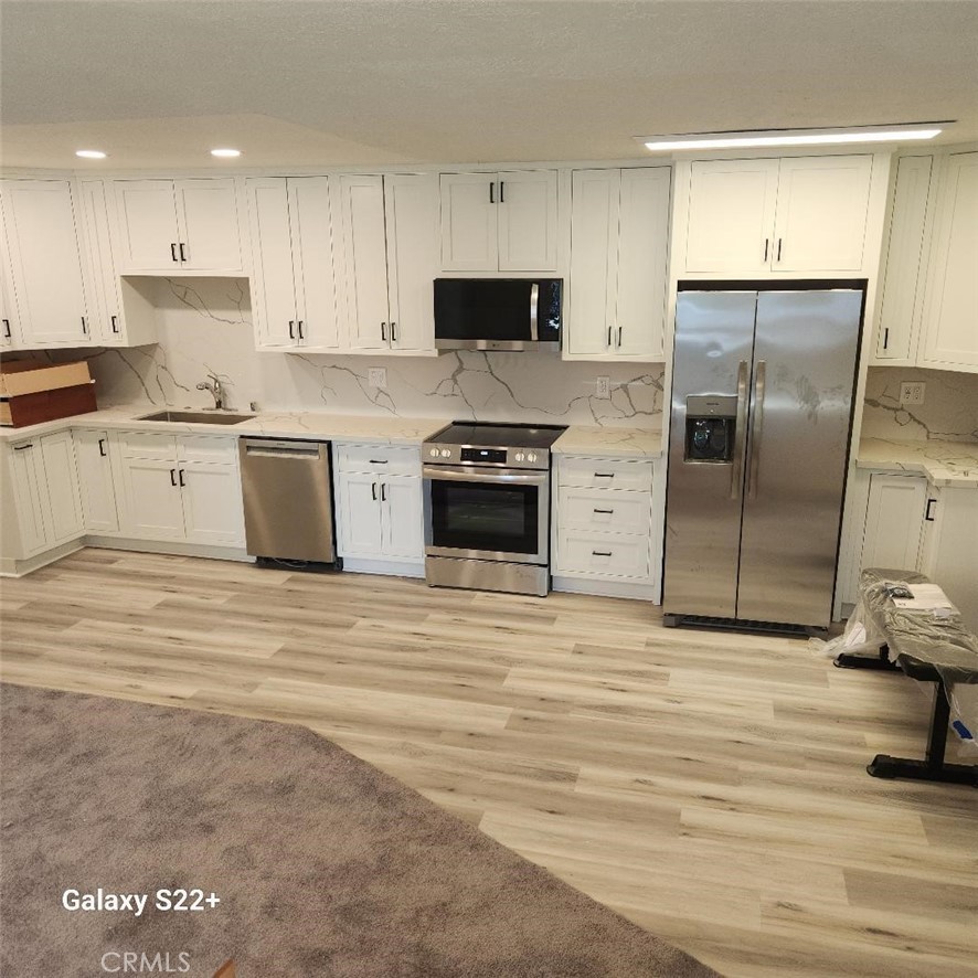 a kitchen with granite countertop a refrigerator and a stove