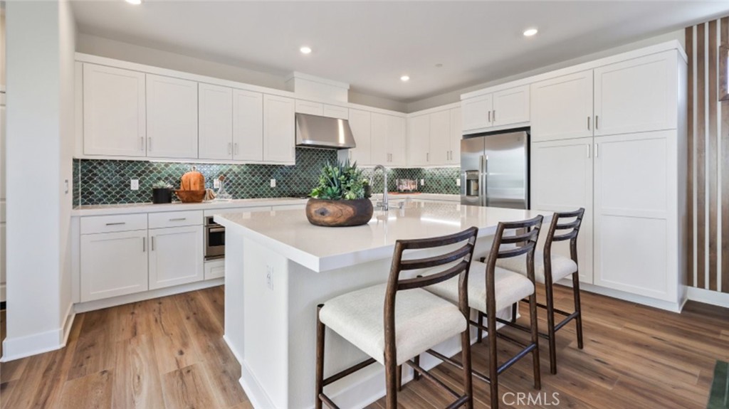 a kitchen with a table chairs stove and white cabinets