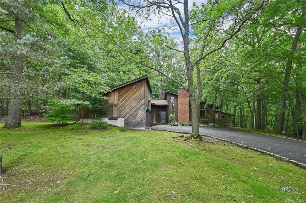 a backyard of a house with entertaining space and large trees