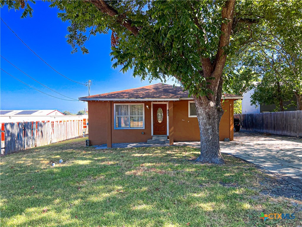 a view of a house with a yard and tree