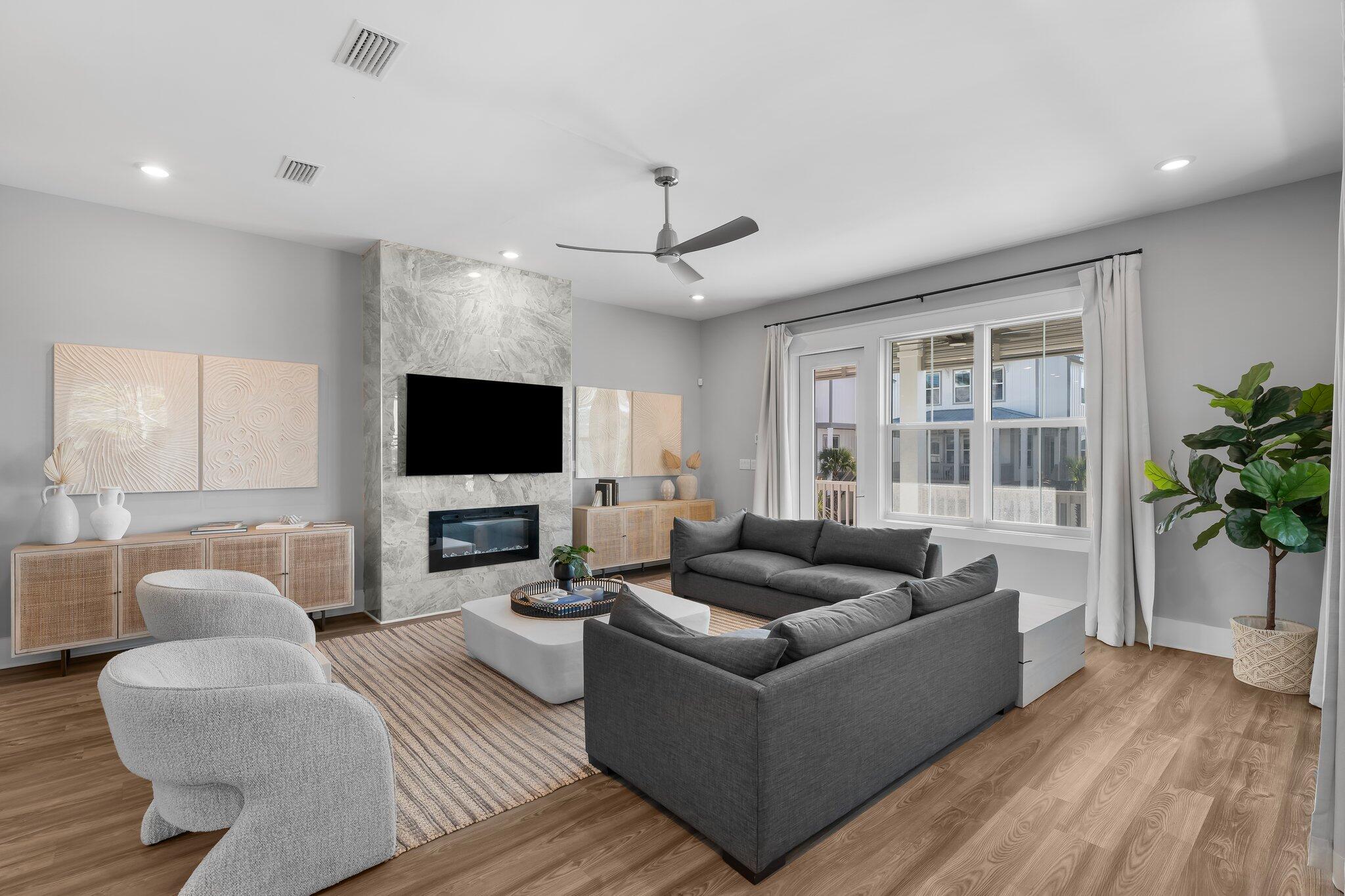 a living room with furniture flat screen tv and a large window