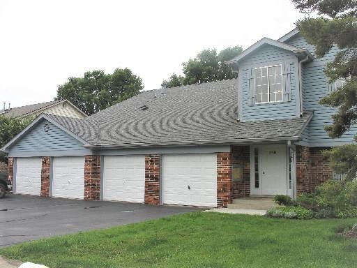 a front view of a house with a garden and yard