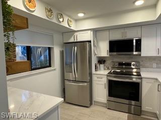 a kitchen with stainless steel appliances a refrigerator stove and microwave