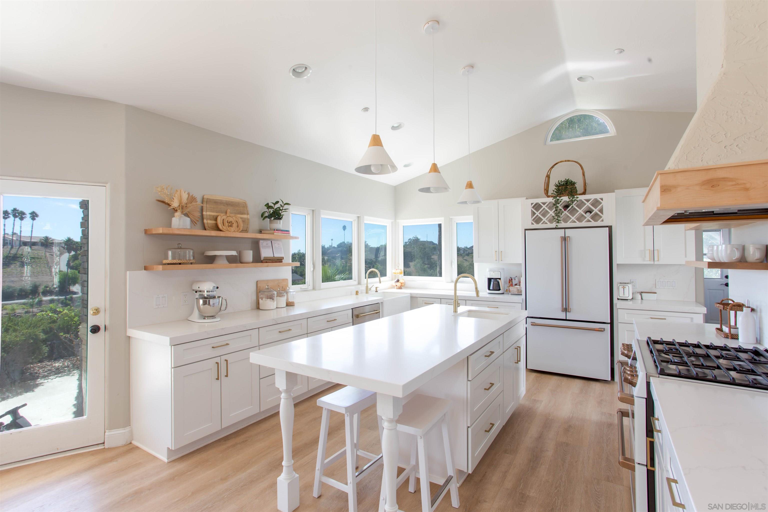 a large white kitchen with cabinets and stainless steel appliances