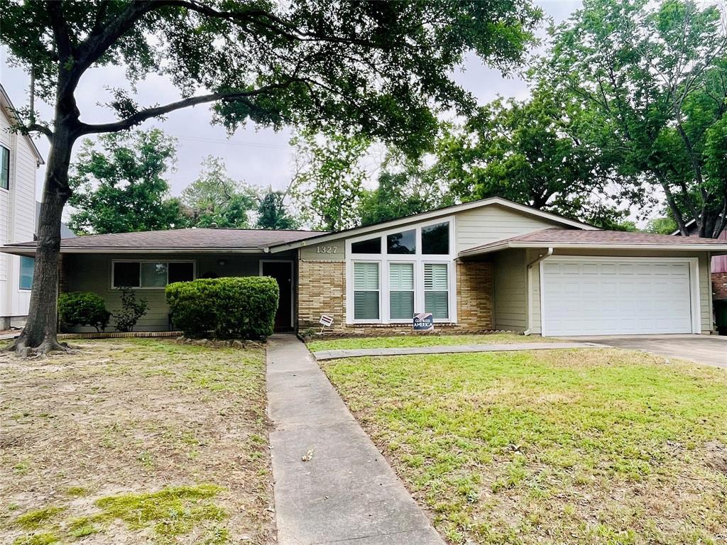 a front view of house with yard and trees around