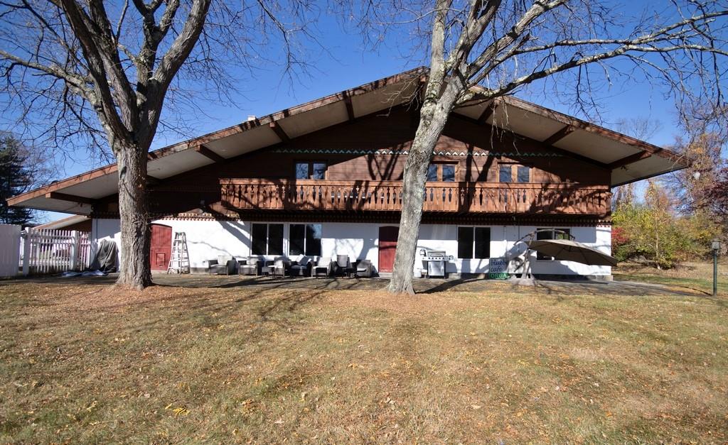 Rear view of property with a lawn