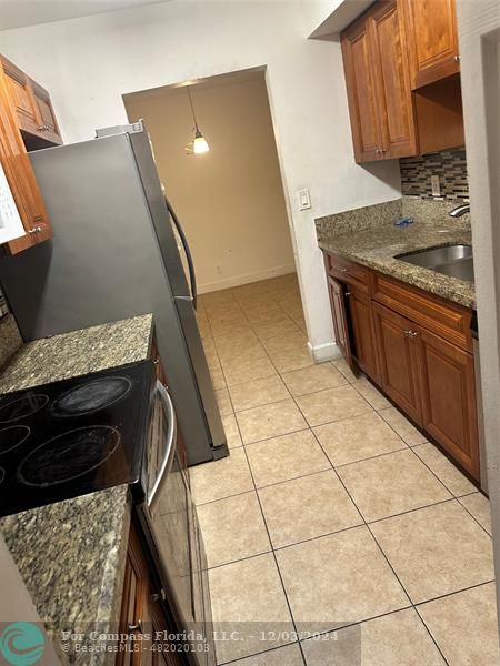 a kitchen with granite countertop a stove a sink and a microwave