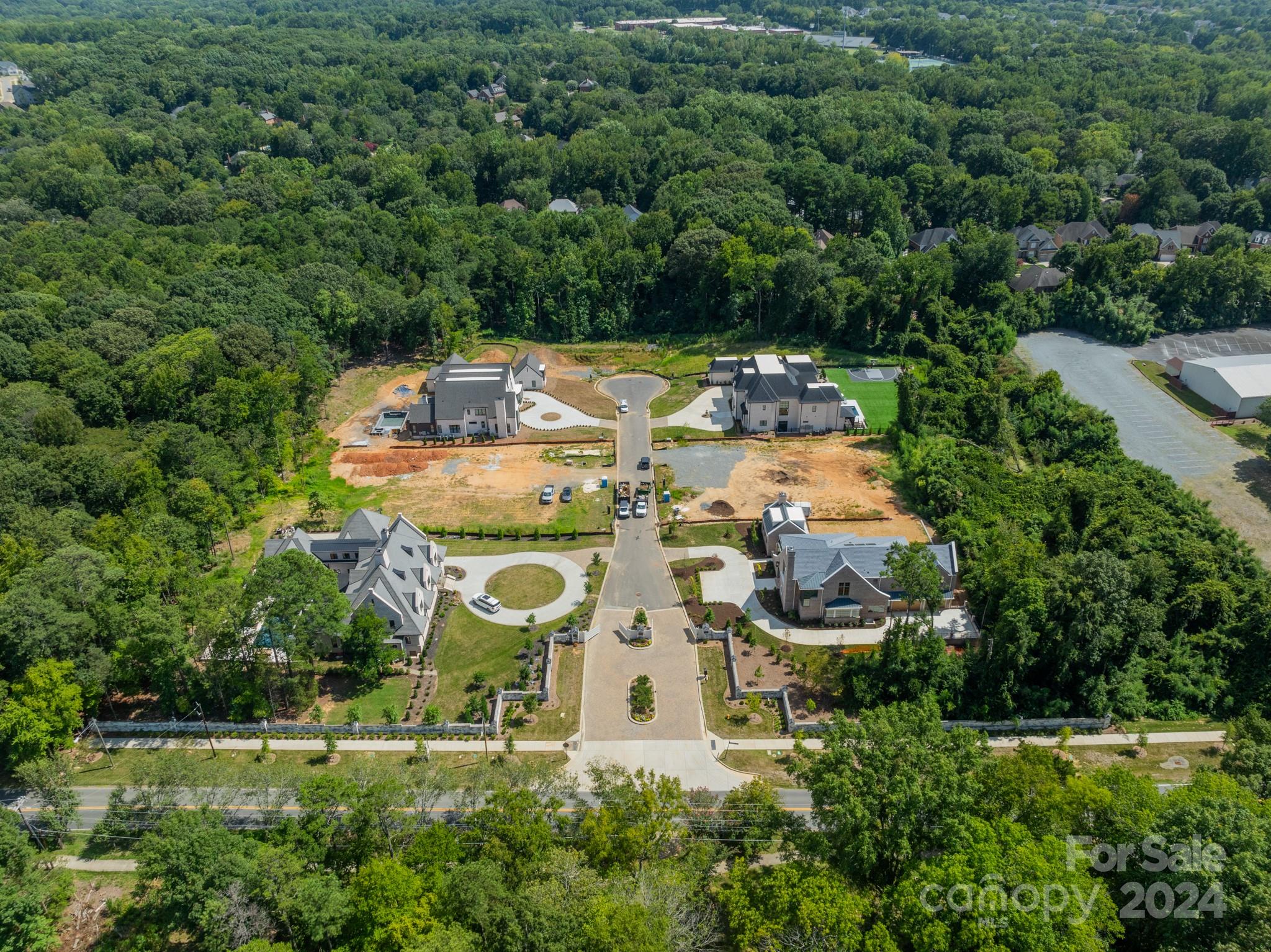 an aerial view of residential houses with outdoor space and trees