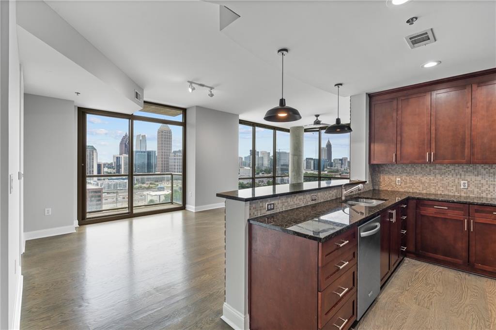 a kitchen with stainless steel appliances granite countertop a stove a sink and a wooden cabinets