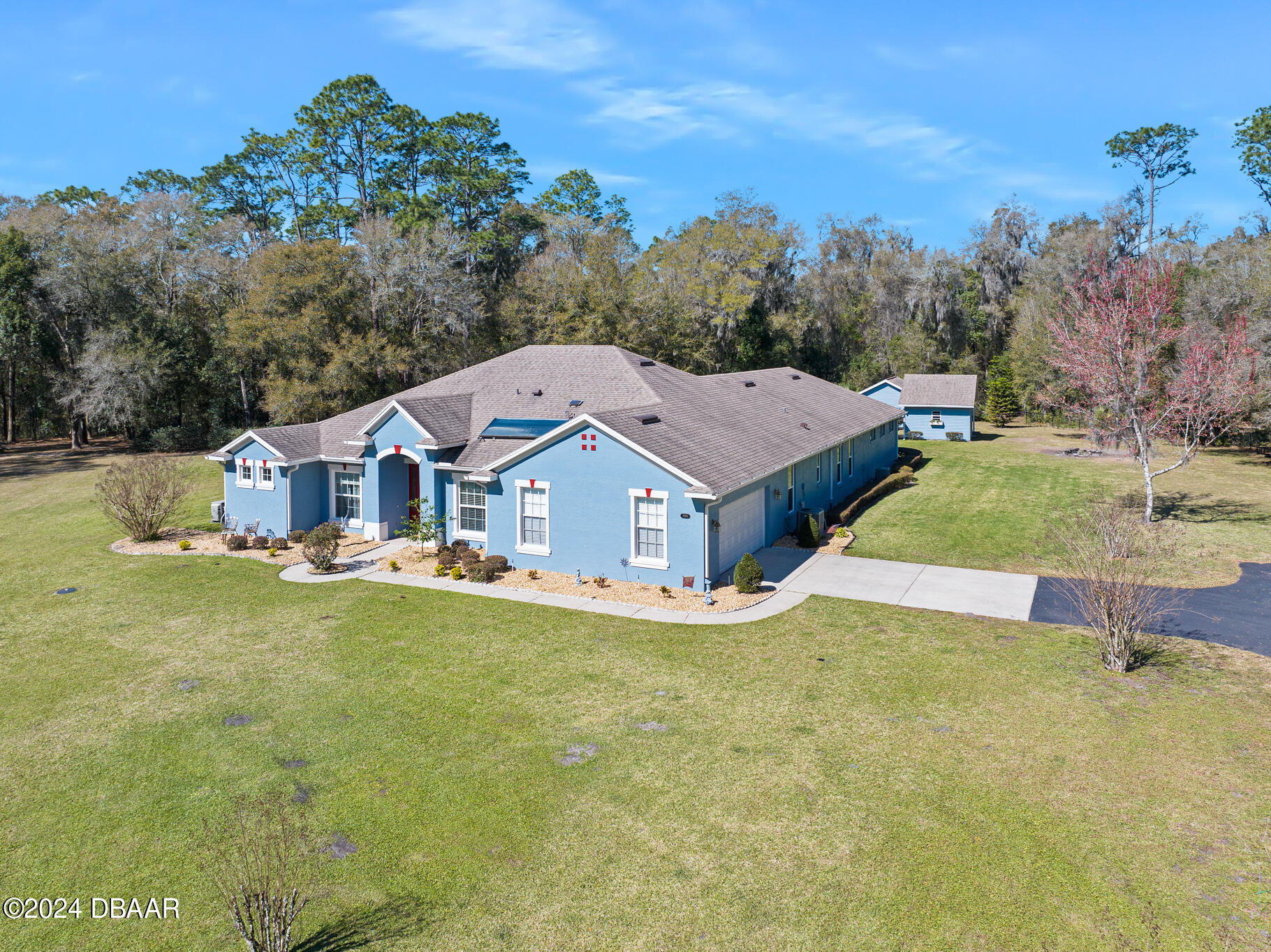 an aerial view of a house with swimming pool and a yard