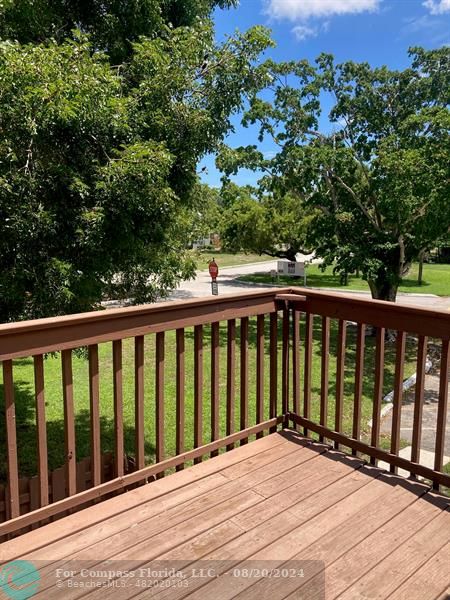 a view of balcony with wooden floor and fence