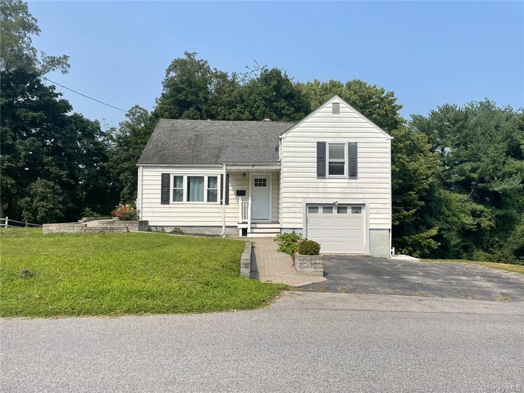 View of front of property featuring a garage and a front yard