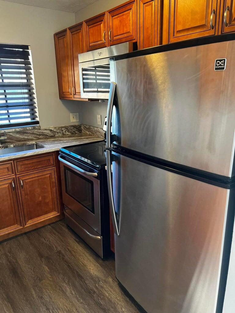 a kitchen with granite countertop a refrigerator and a sink