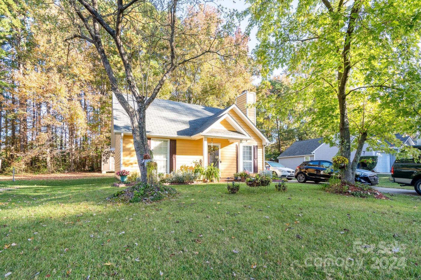 a front view of a house with a yard and trees