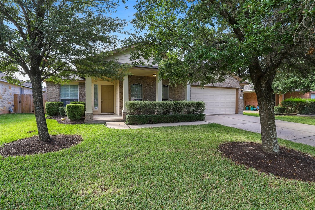 a view of a house with backyard and a tree