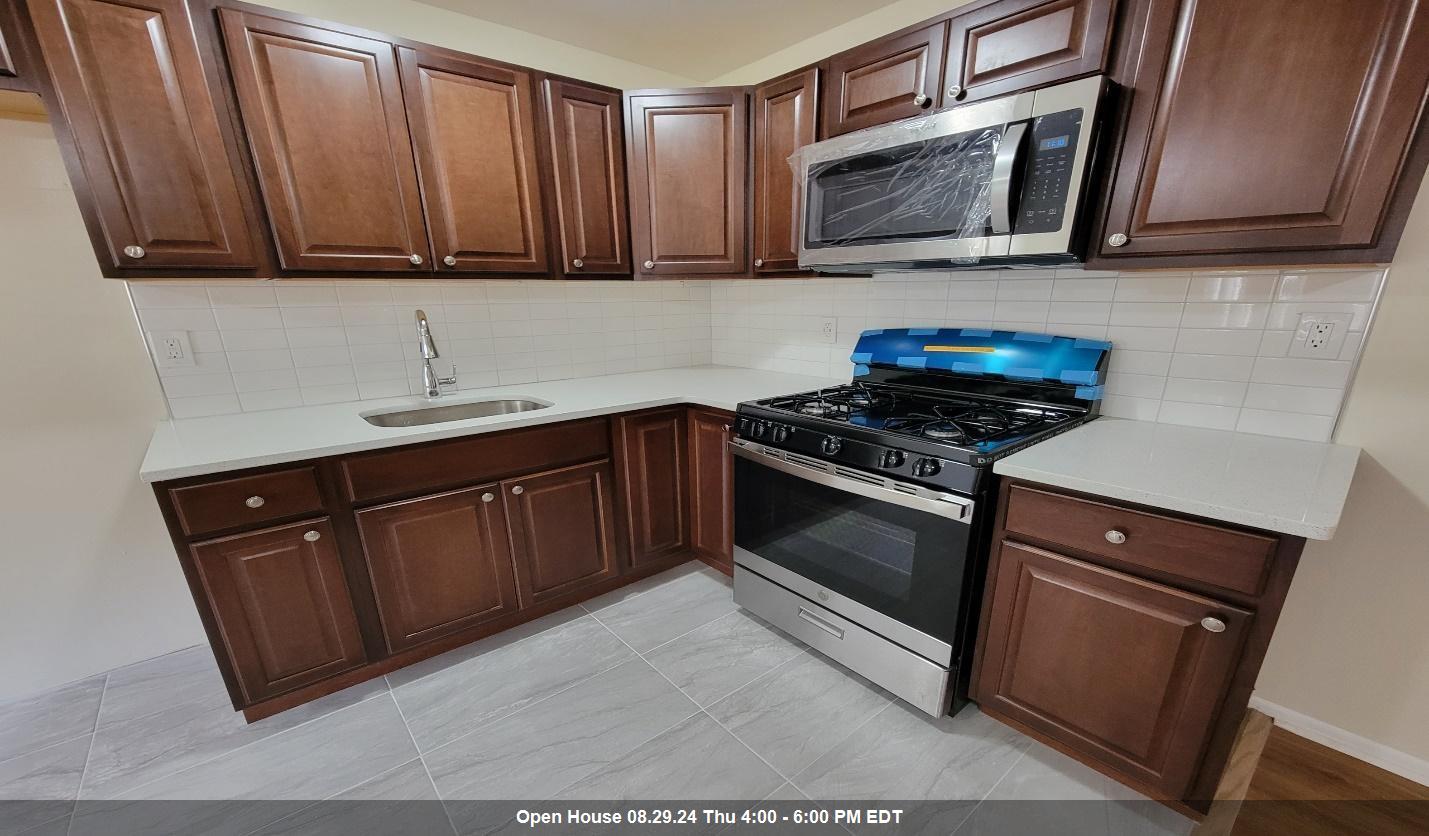 a kitchen with granite countertop wooden cabinets and stainless steel appliances