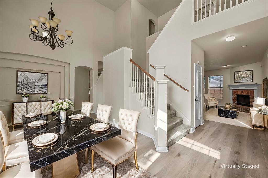 a dining room with wooden floor a chandelier a wooden table and chairs