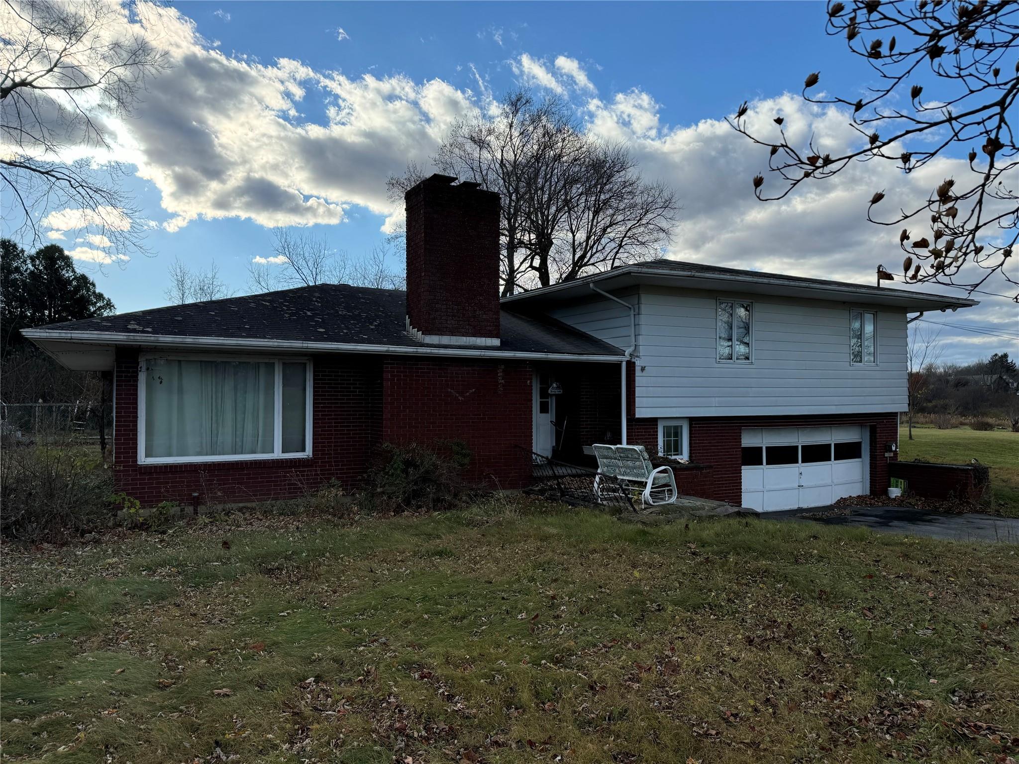 Rear view of property featuring a yard and a garage