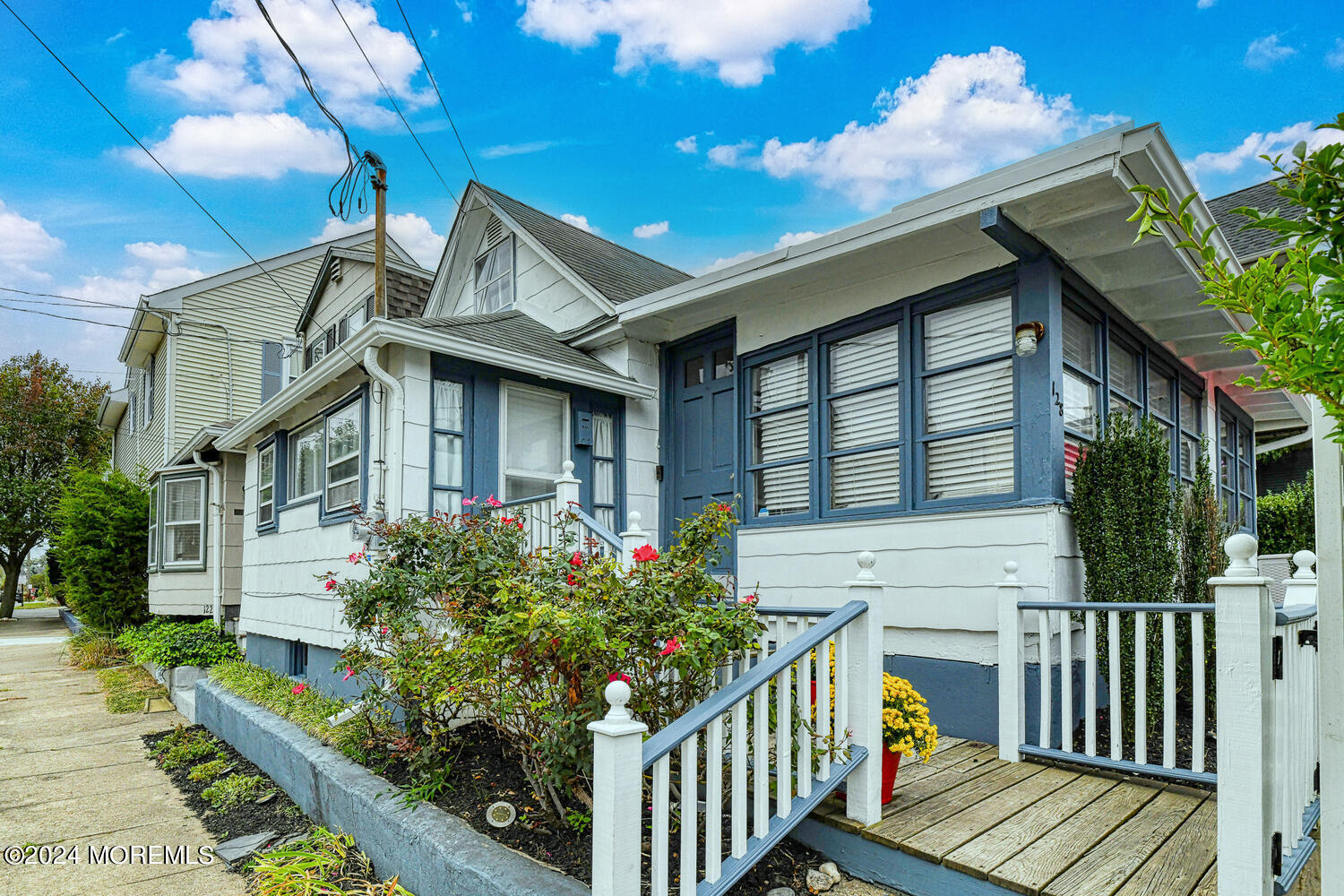 a front view of house along with deck and outdoor seating