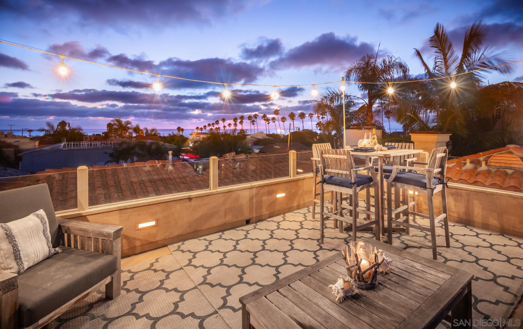 a view of a rooftop deck with couch and chairs