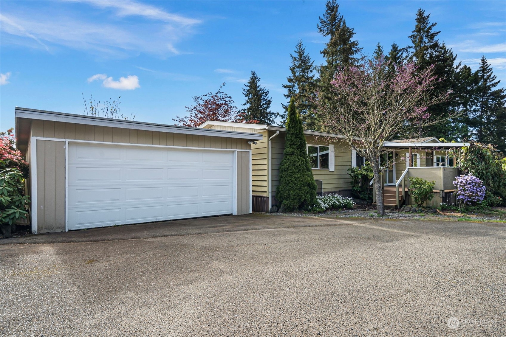 a front view of house with yard and trees in the background