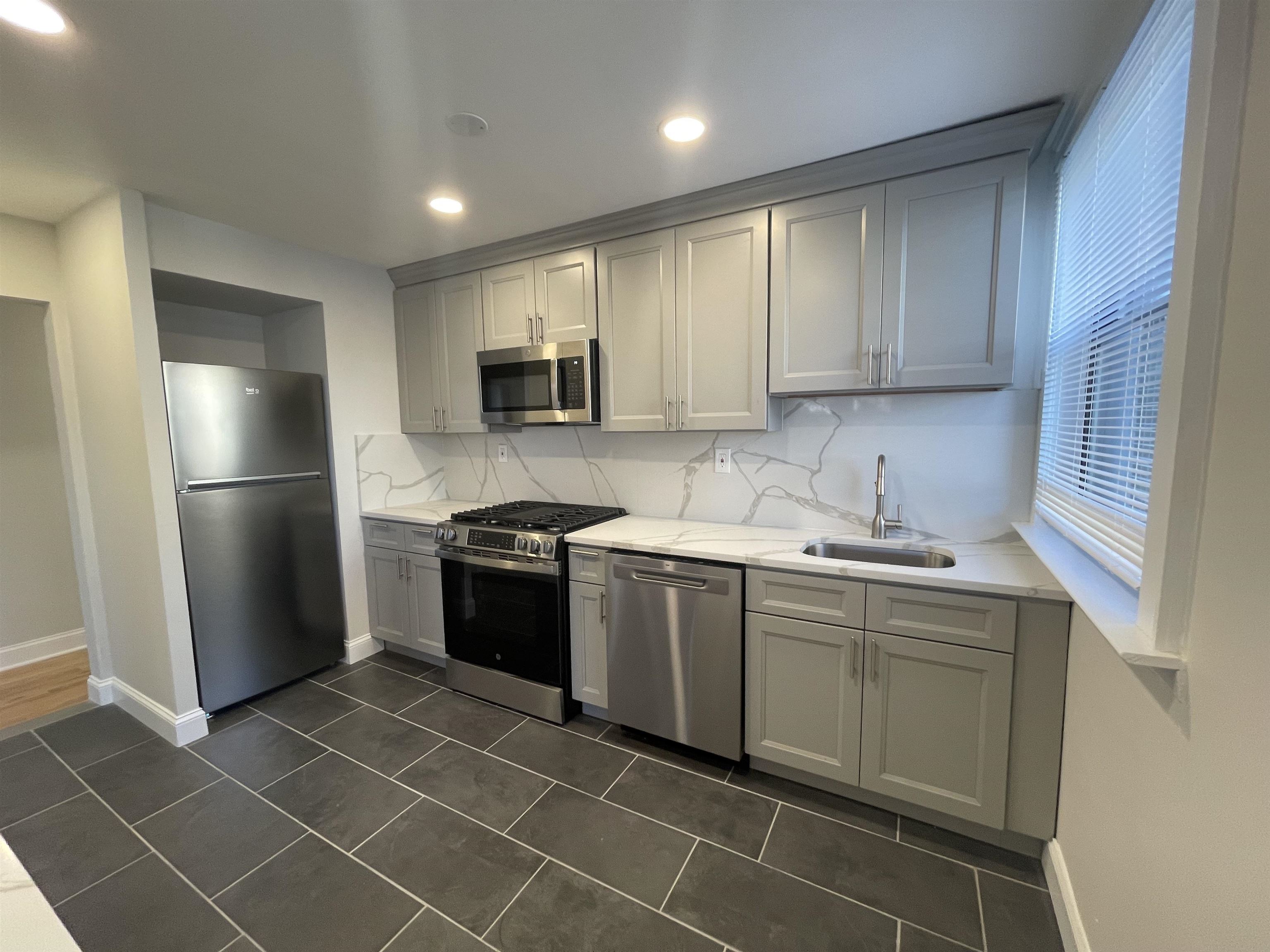 a kitchen with a sink a refrigerator and cabinets