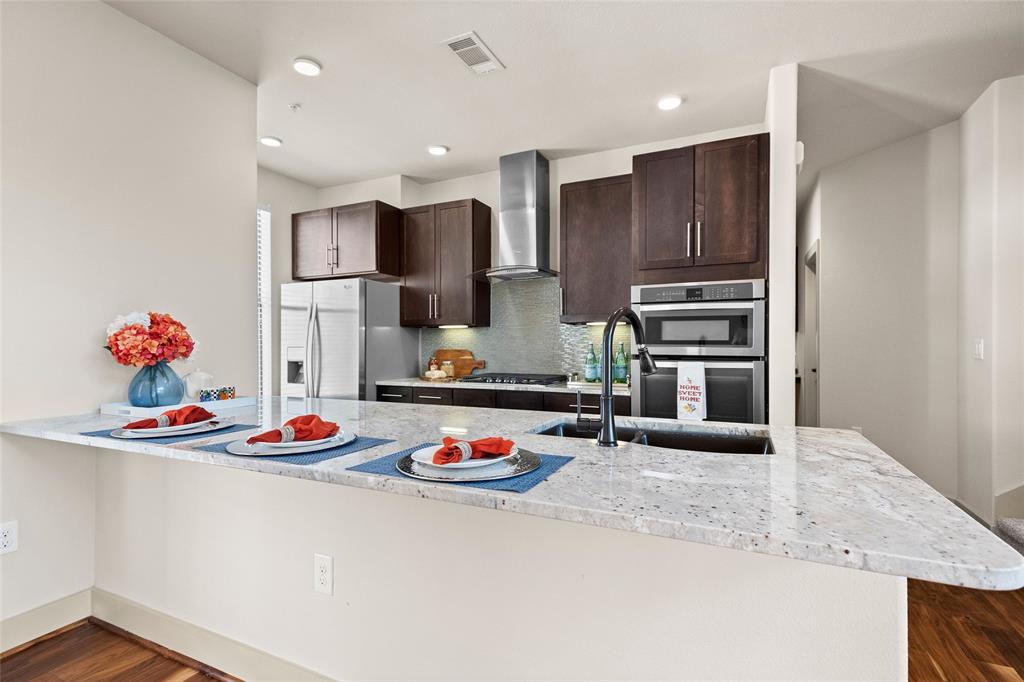 a kitchen with stainless steel appliances granite countertop a refrigerator and a sink