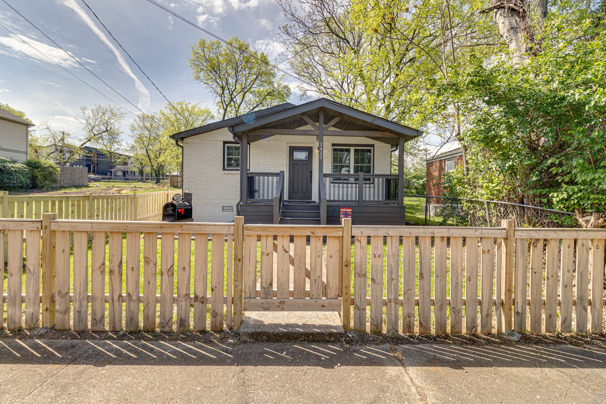 a view of a small house with wooden fence