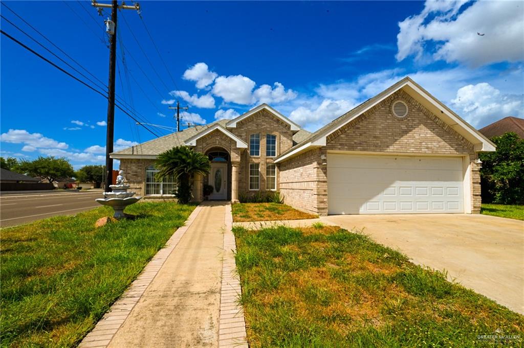 View of front facade featuring a front yard and a garage