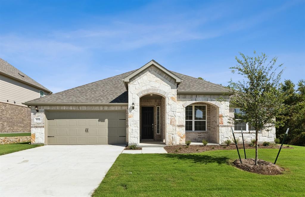 a front view of a house with a yard and garage