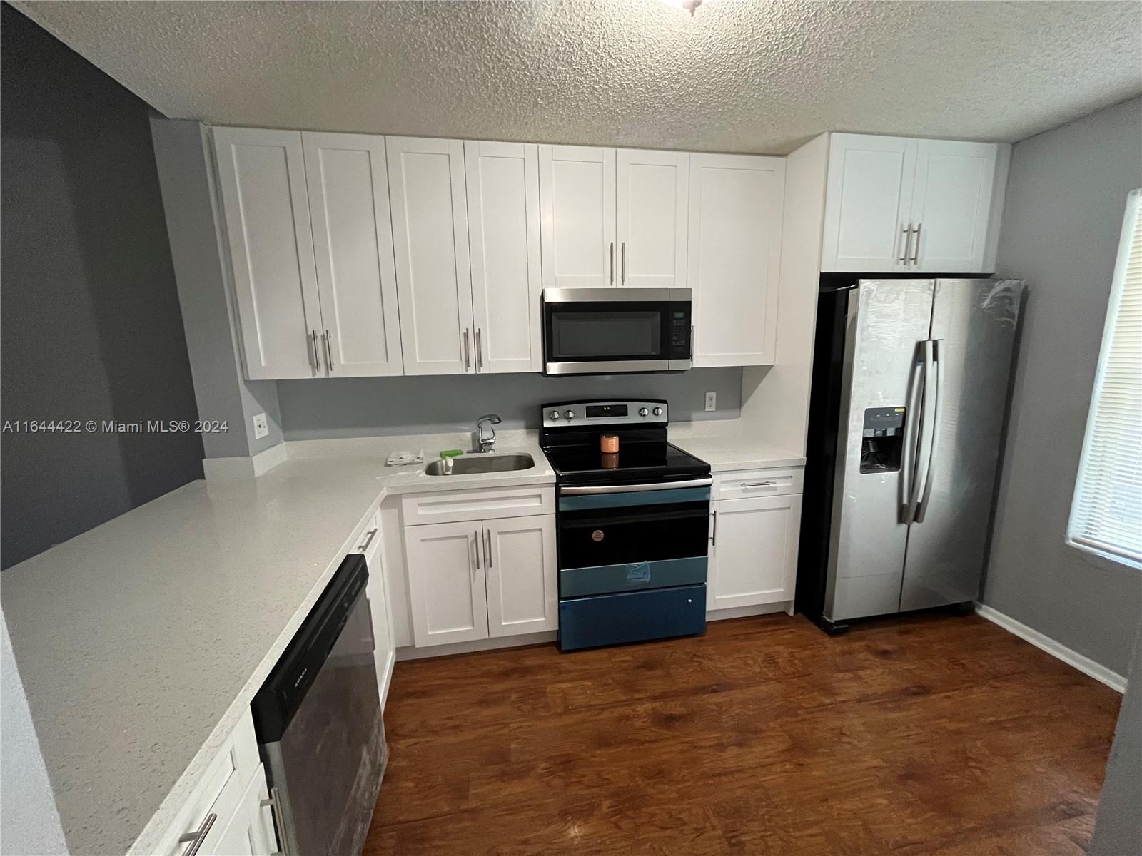 a kitchen with a refrigerator sink and stove top oven