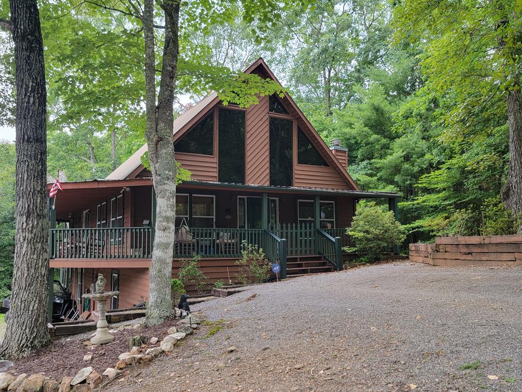 a view of a house with a yard and large trees