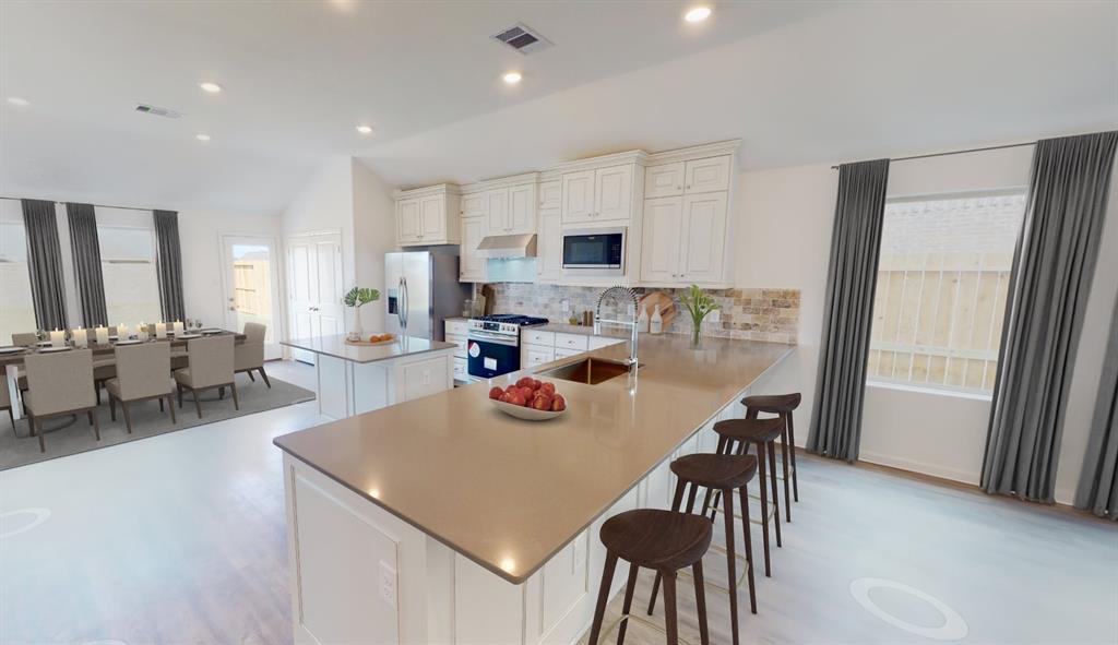 a kitchen with a dining table chairs and refrigerator