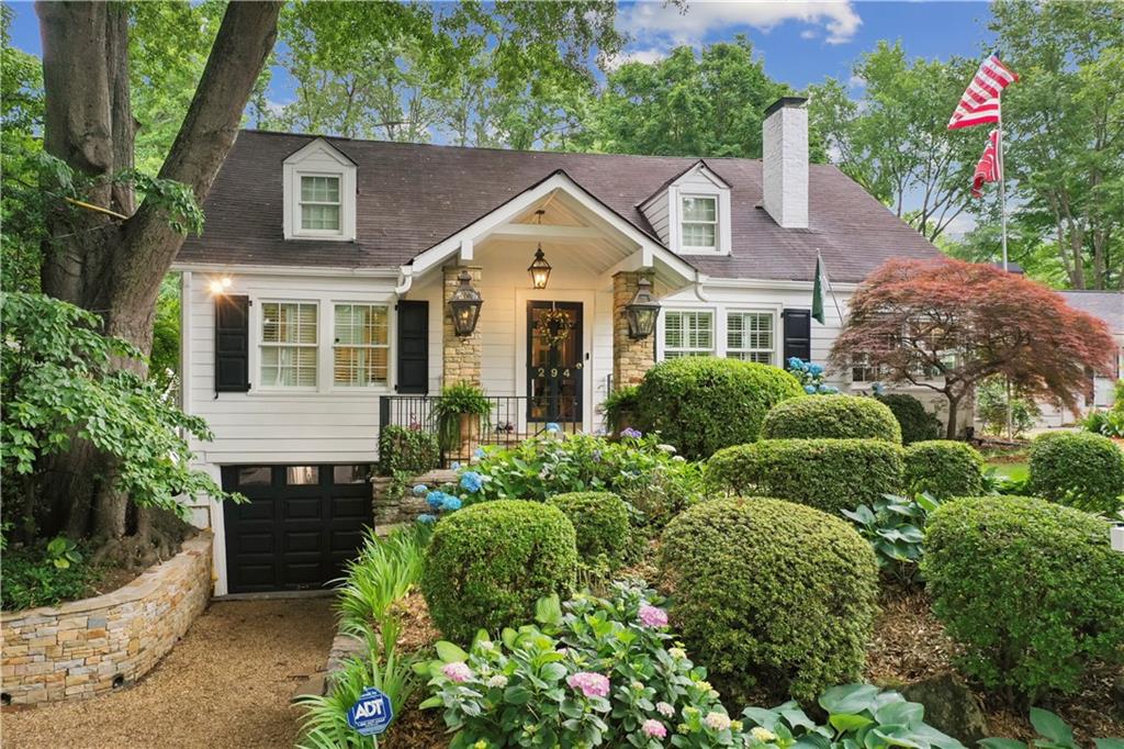 a view of a house with a yard and potted plants