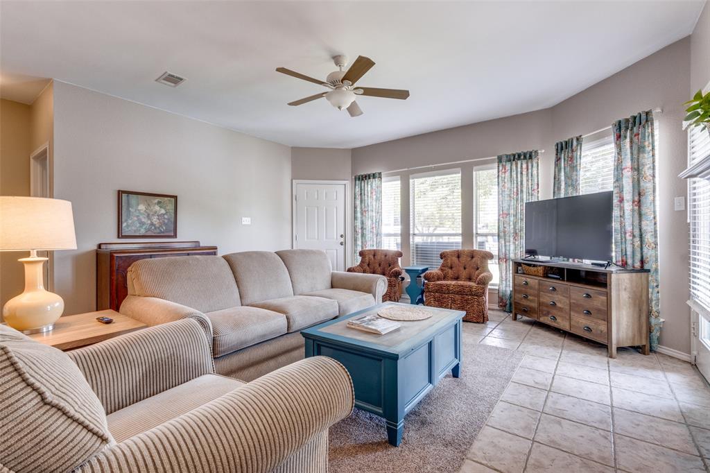 a living room with furniture a flat screen tv and a large window